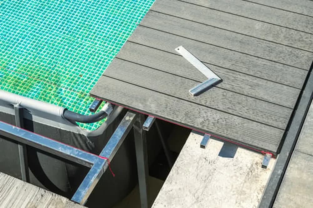 Swimming pool under construction with decking being installed at the edge