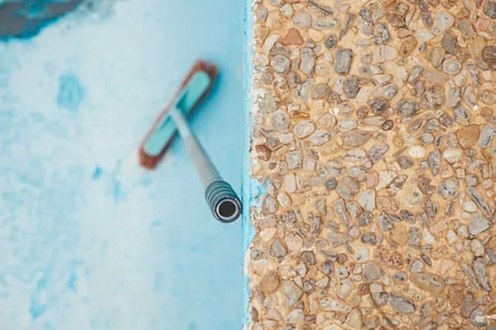Pool brush on a freshly finished pebble and plaster pool surface